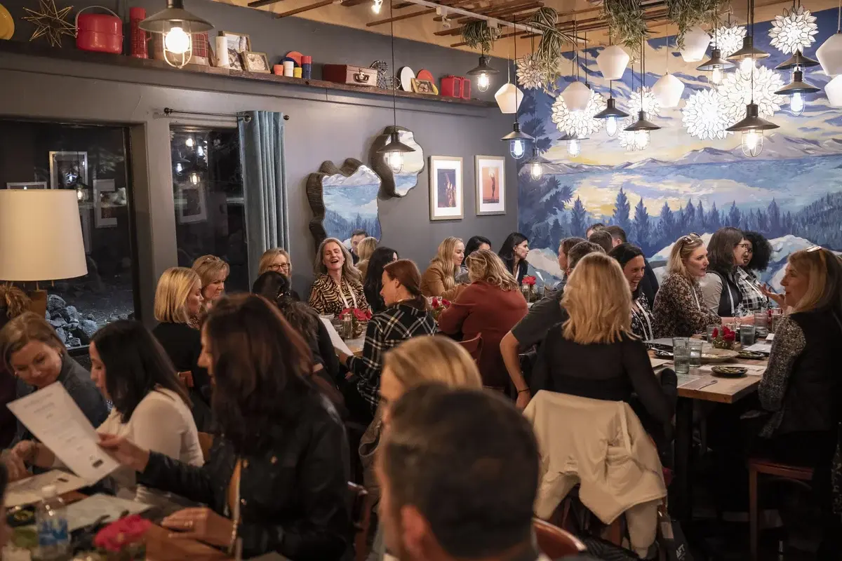 AFT Women in FinTech 2023 — attendees gathered at dinner event with mountain mural backdrop