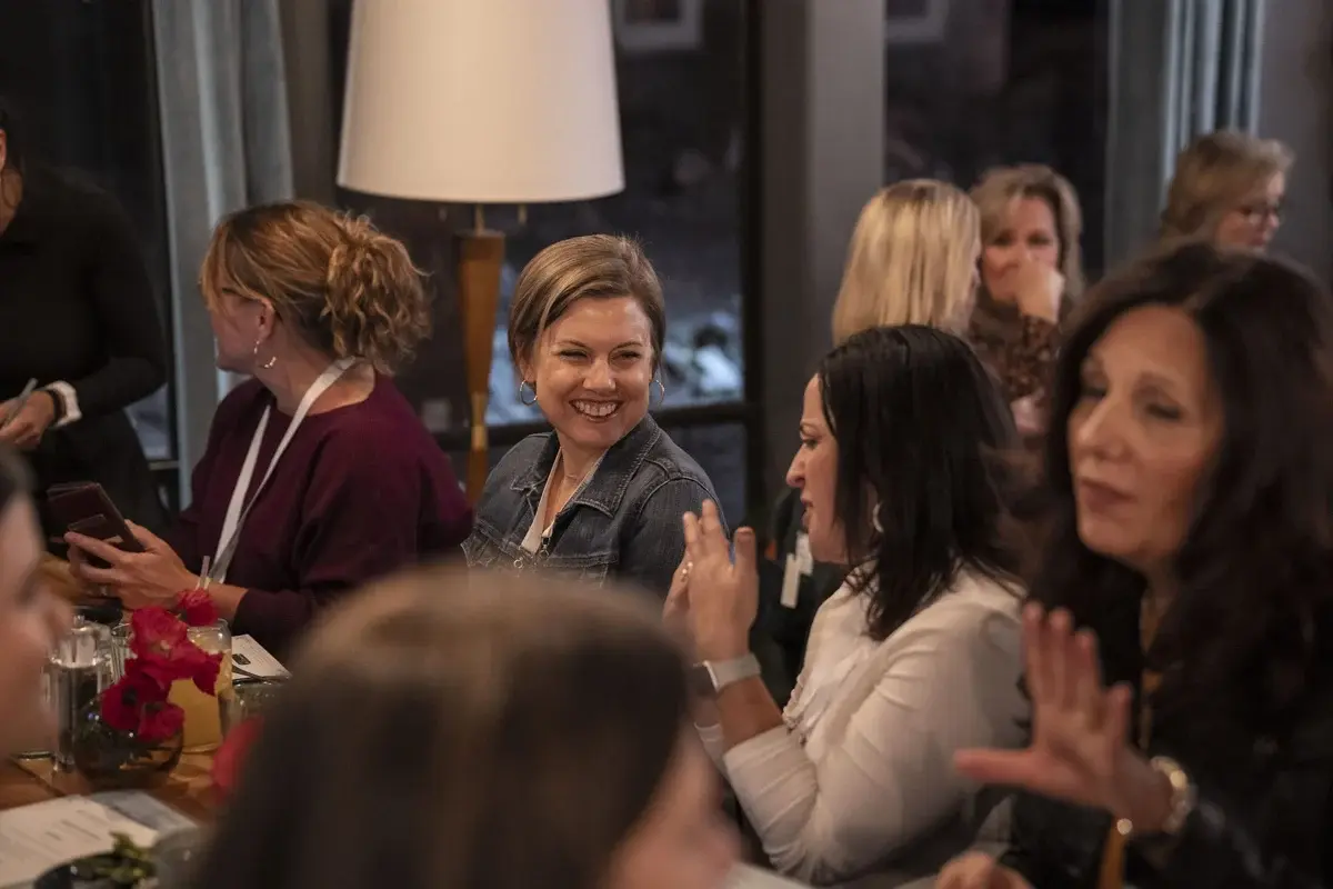 AFT Women in FinTech 2023 — attendee smiling at dinner table, engaged in conversation
